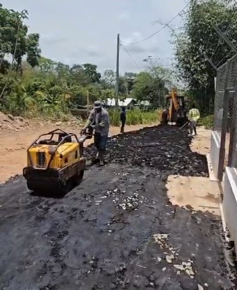 A Jamaal's Industrial crew compacting a freshly laid asphalt road surface with a plate compactor